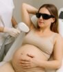 Zwangere vrouw ondergaat definitief ontharen van de oksel in een kliniek