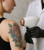 Specialist bereidt tattoo weglaseren voor op kleurrijke tattoo tijdens intakegesprek